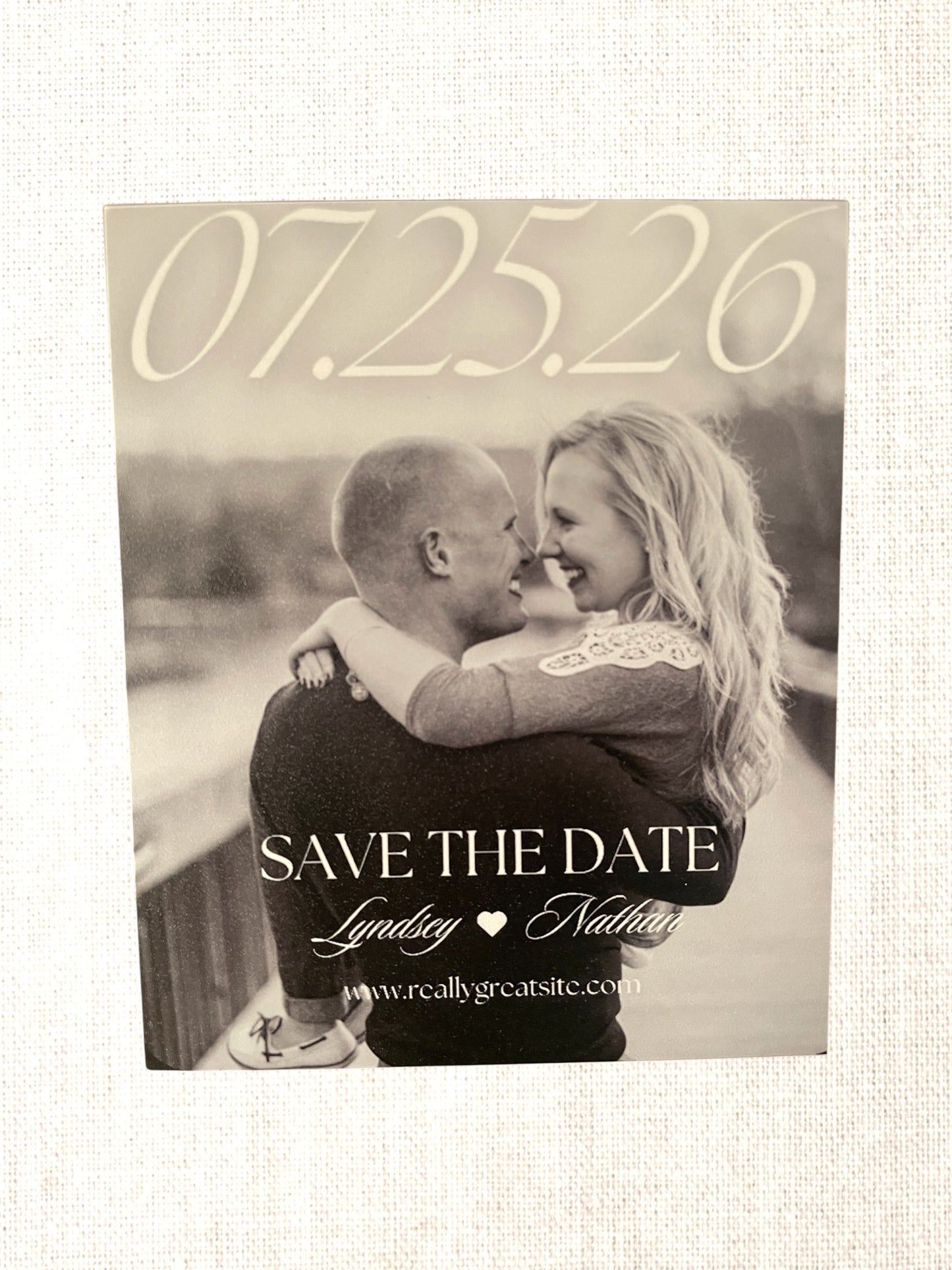 Save the Date card with a black and white photo of a couple embracing.